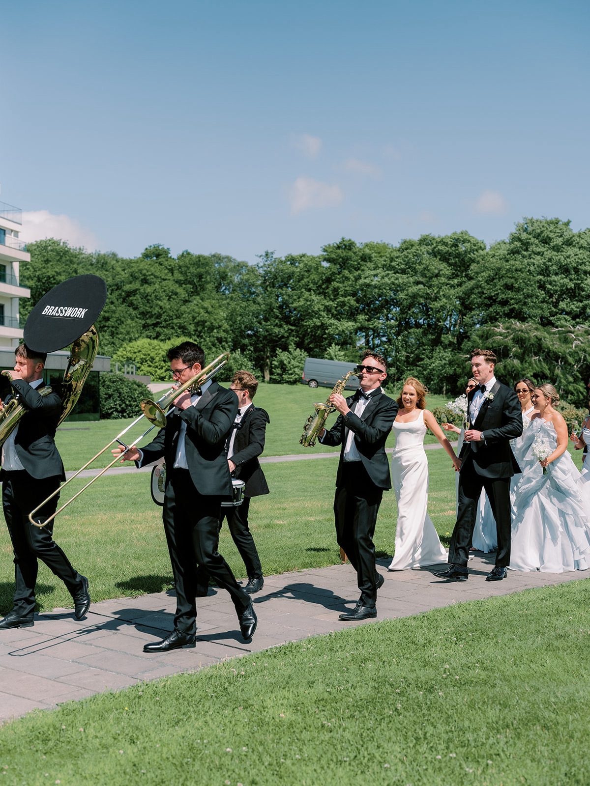 The band marching along the path with the couple and guests following